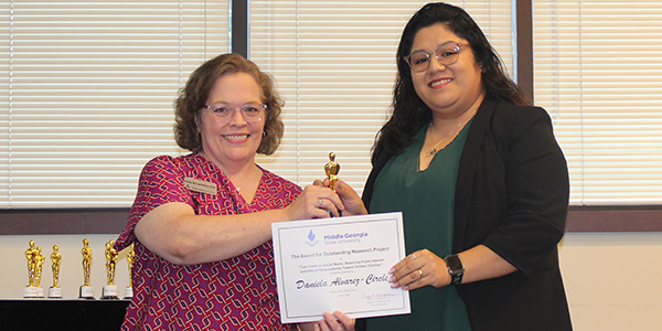 Daniela Alvarez-Circle (right) receives the Outstanding Research Project for Media Ethics Award from Dr. Cindy Montgomery, Assistant Professor of Media and Communication.